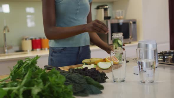 Midsectin of african american attractive woman preparing smoothie in kitchen