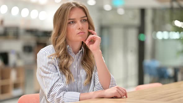 Worried Businesswoman Sitting in Office and Thinking 