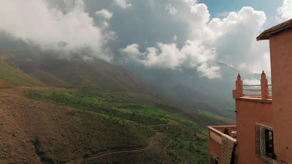 Hiking path in High Atlas mountains with typical house in foreground, Morocco