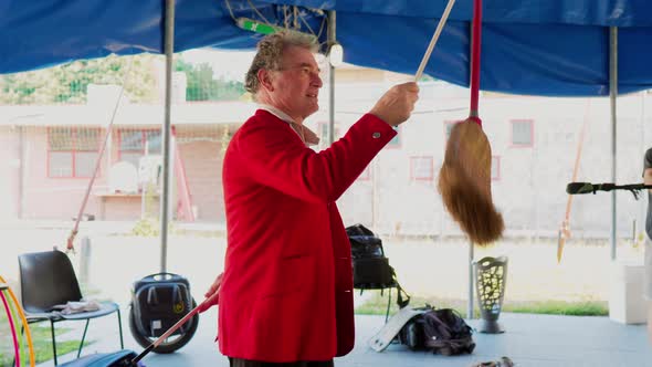 Circus artist practicing juggling trick with broom stick