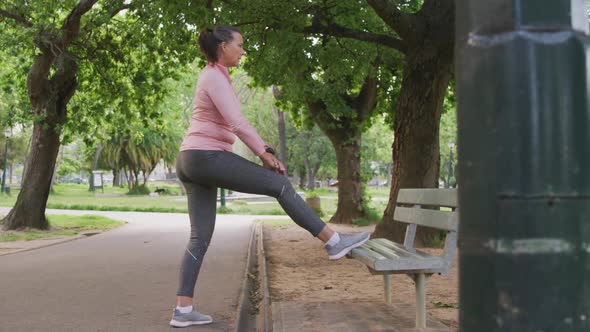 Senior woman stretching her legs in the park
