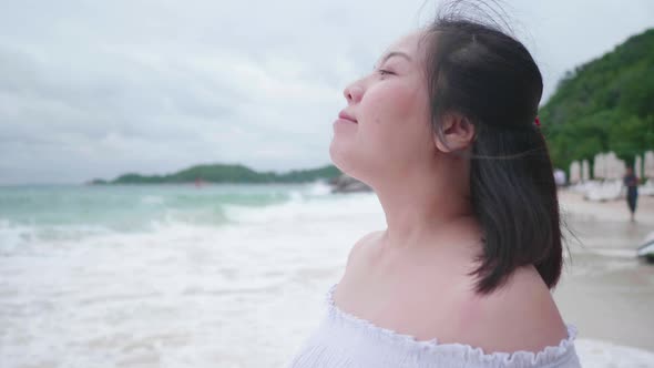 Slow motion Asian short hair woman deep breath on beach blue sea