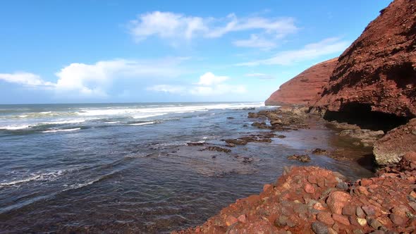 Panoramic View of Blue Ocean Coast with Red Rocks Cliff in Sunny Day in Morocco Beach