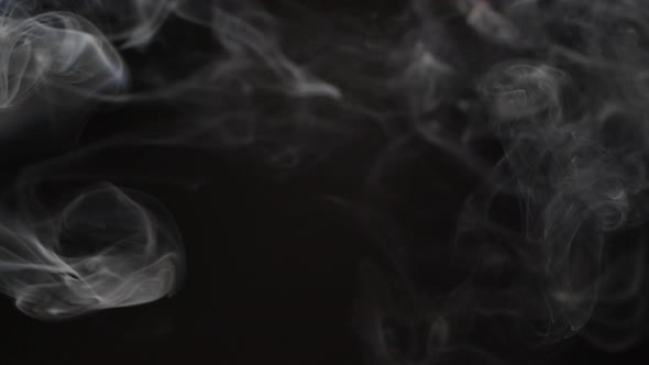 Slow motion of white abstract cigarette smoke on black background