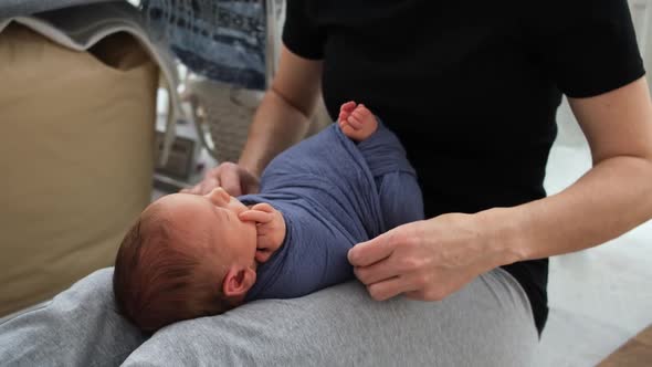 Woman Swaddles Newborn Baby