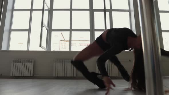 Flexible Woman Dancing on Pole in Studio