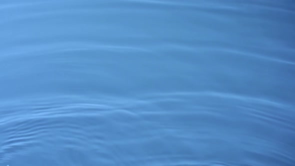 Slo-motion water rippling against blue background