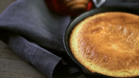 Slice of sweet cornbread with honey on the plate