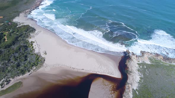 Aerial tilt shot over lagoon revealing beach, ocean and town along coastline, Kleinmond, South Afric