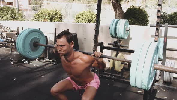 Outdoor Gym and Shot of Man's Back Doing the Tire Flip Exercise