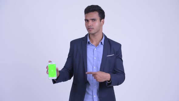 Happy Young Indian Businessman Showing Phone and Giving Thumbs Up