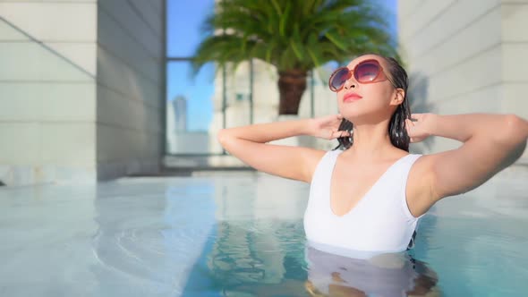 Young asian woman enjoy around outdoor swimming pool for leisure