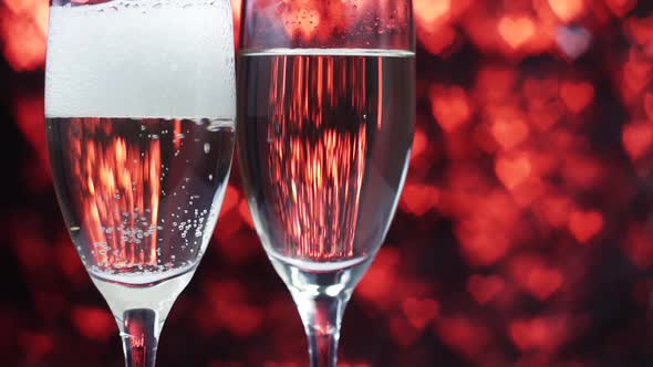 Champagne Is Poured Into a Glass on a Red Background with Many Hearts Close Up