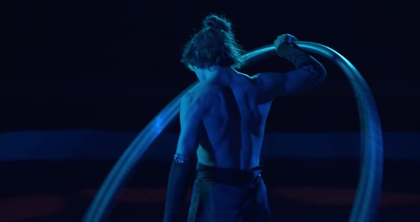 Athletic Young Man Is Spinning a Big Hoop Around Himself Circus Show