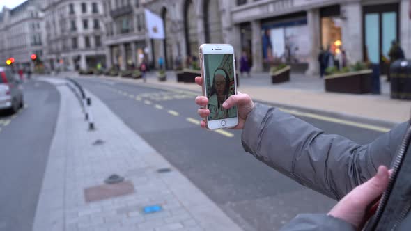 Girl taking selfie in streets of London.