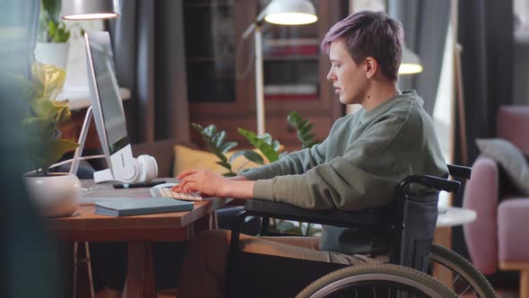 Young Woman on Wheelchair Using Computer at Home