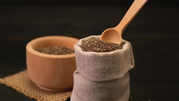Pouch Full of Organic Natural Chia Seeds on Dark Wooden Background or Table