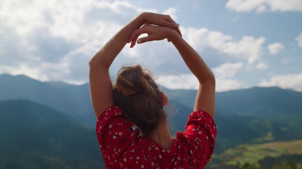 Back View Carefree Woman Holding Hands Over Head Relaxing on Mountains Close Up