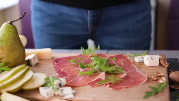 Making Pear and Blue Cheese Salad  Arugula Leaves Falling on Jamon Slices