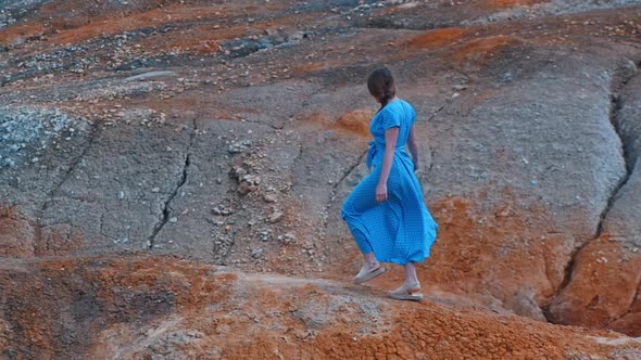 Young Woman Traveler Walking on an Orange Clay Mountains