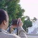 Back view of Asian woman standing and taking a picture at park - VideoHive Item for Sale