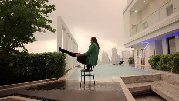 Dancer Posing And Stepping From Chair At Poolside