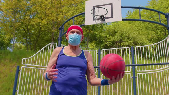 Active Senior Handsome Man Playing Basketball Outdoors on Sports Playground Court During Coronavirus