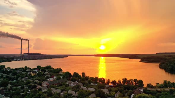 Orange sun reflection in the water at beautiful rural background in summer at sunset.