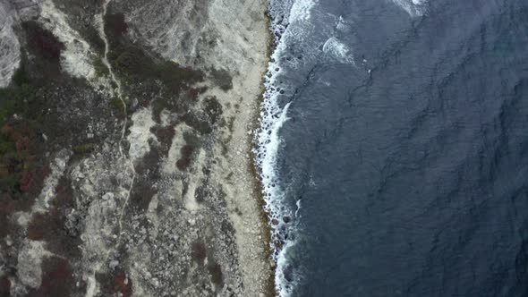 Shooting From Helicopter Flying Over Natural Coastline with Wavy Sea and Cliff Rocky Terrain