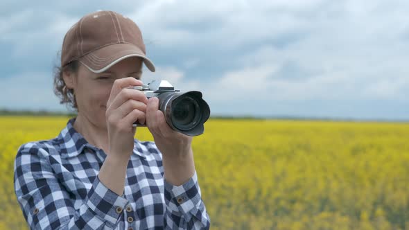 Female photographer in a yellow flowered field.