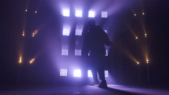 Silhouette of a Talented Young Hip Hop Dancer. Hip Hop Street Dance on a Stage in Dark Studio with