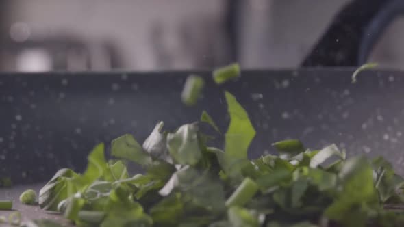 Greenery and Scrambled Egg Falling Into the Frying Pan. Slow Motion