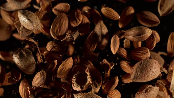 Super Slow Motion Shot of Flying Whole Almonds and Nut Shells Towards Camera on Black at 1000Fps