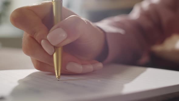 Hands of Businesswoman Writing in Notepad