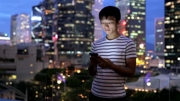 Man using mobile phone in city at night 