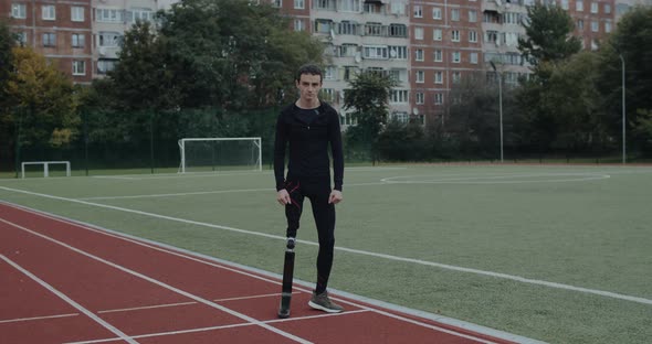 Handsome Disabled Man with Prosthetic Running Blades Turning and Looking To Camera