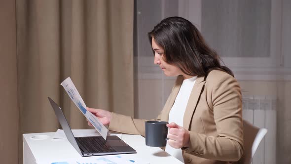 Serious Corporate Worker Looks at Sheet of Paper with Graphs