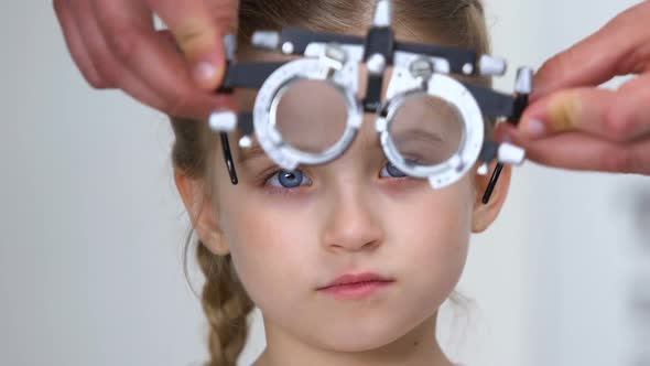 Pretty Female Kid in Optical Trial Frame, Optometrist Choosing Proper Lens