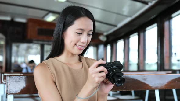 Woman taking photo with digital camera on ferry 