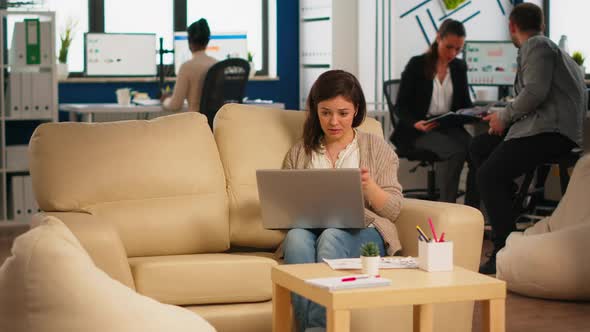 Business Woman Talking During Video Conference Calling From Laptop Sitting on Couch