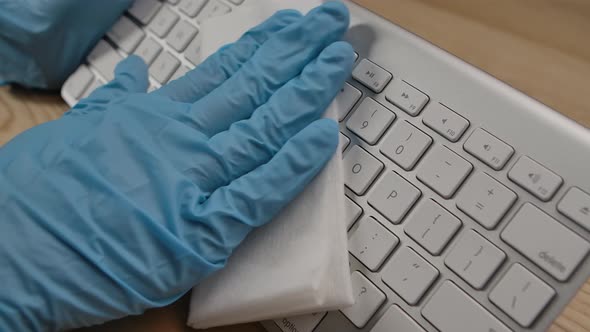 Man in Protective Gloves Cleaning Keyboard Surface with Alcohol Disinfectant and Removing Dirty with