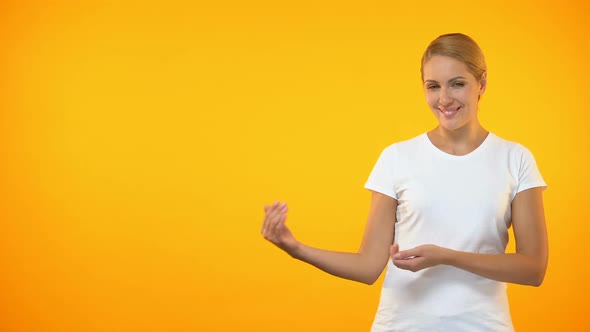 Young Smiling Woman Presenting Template on Orange Background, Announcement