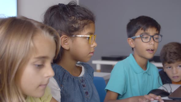 Smart Schoolboy in Glasses Helping Classmates To Do Task