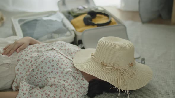 Travel Asian woman sleeping rest after packing suitcase planning for the summer holiday.