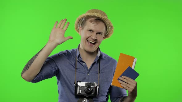 Portrait of Man Tourist Photographer with Passport and Tickets Waving His Hand