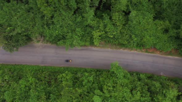 Woman Riding Motorbike On The Road Cross The Forest