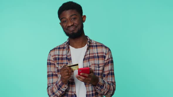 Young Man Using Credit Bank Card and Smartphone While Transferring Money Purchases Online Shopping