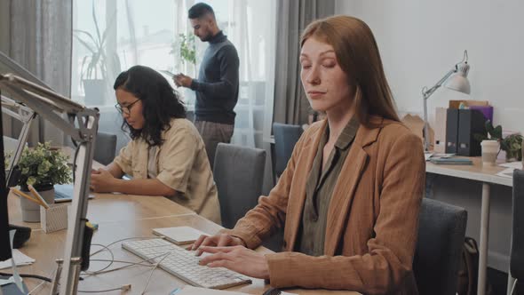 Portrait of Female Office Worker Sitting by Computer