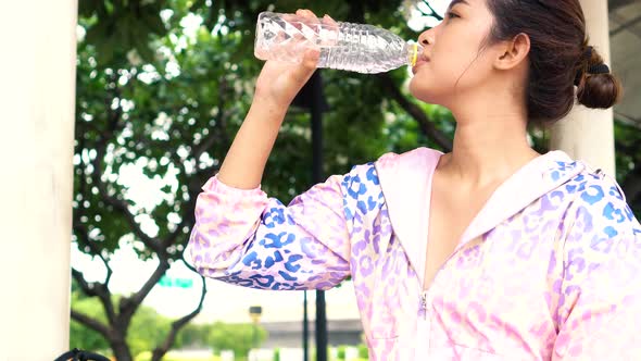 Asian Athlete Drinking Water in the Park