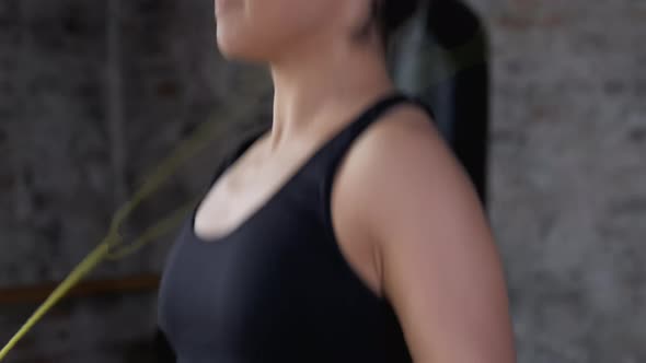 Close-Up of a Young Indian Woman Jumping Rope Dressed in Sportswear Black Top and Leggings